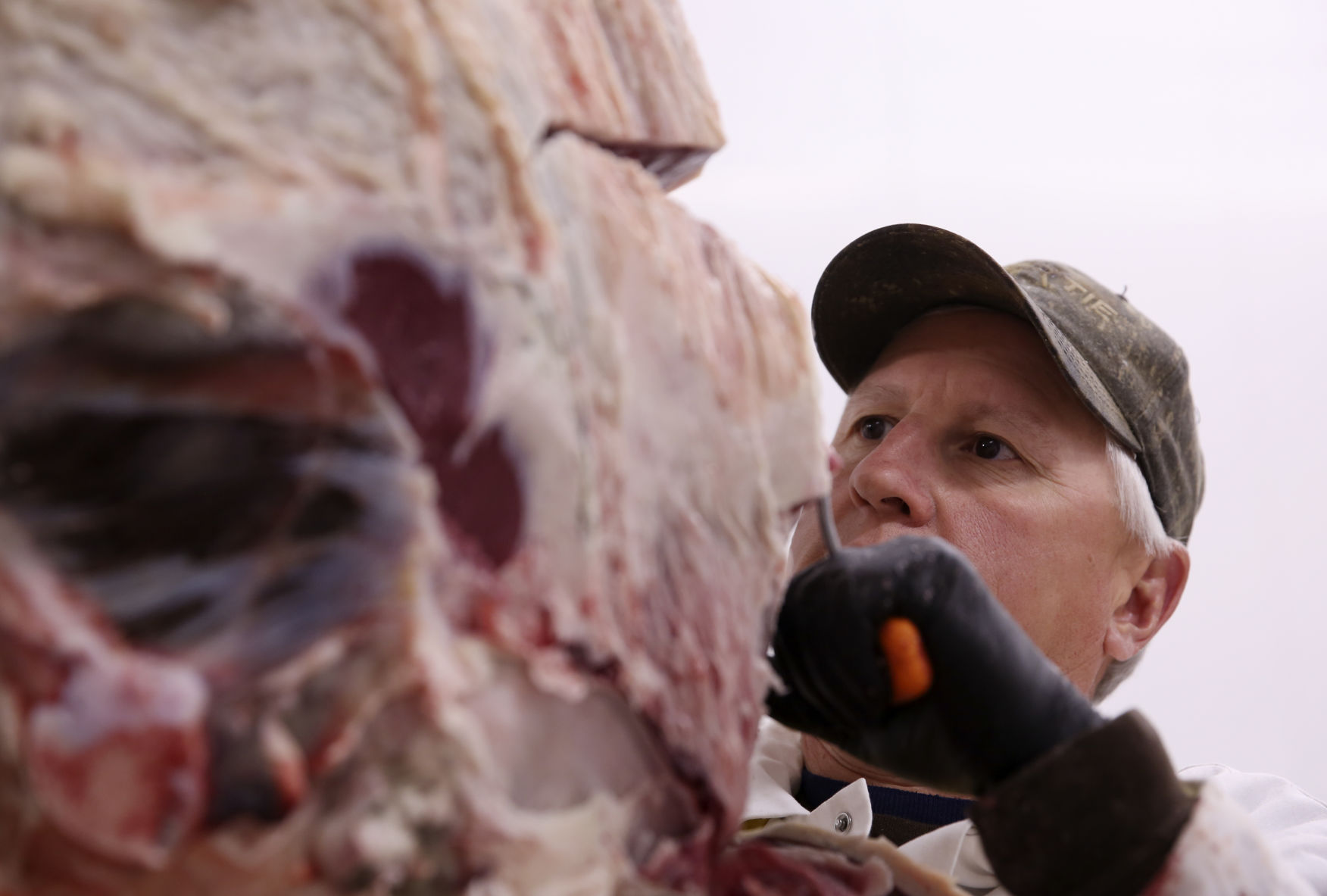 Brandon Purcella removes a section of beef to be cut